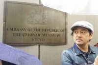 A man waits in the rain outside the Burmese embassy in Tokyo.
